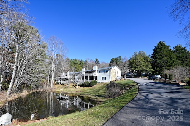 exterior space featuring a water view and a front lawn