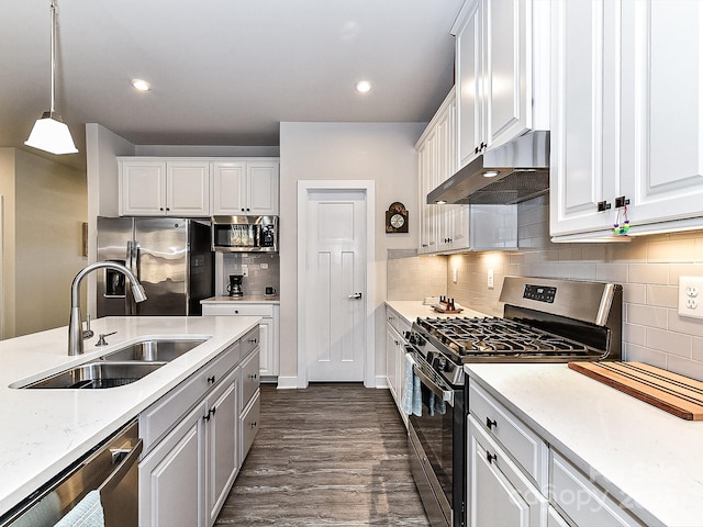 kitchen with stainless steel appliances, pendant lighting, dark hardwood / wood-style floors, sink, and white cabinetry