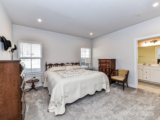 bedroom featuring sink, light carpet, and connected bathroom