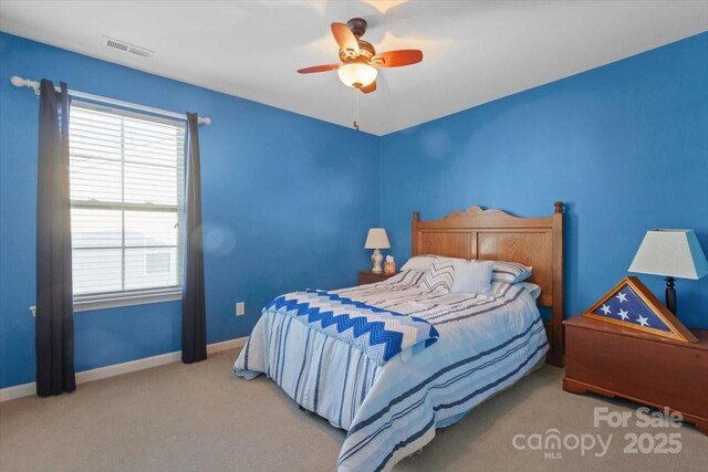 carpeted bedroom featuring ceiling fan and multiple windows