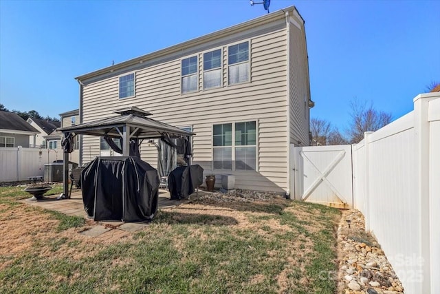 back of house featuring a gazebo and a lawn