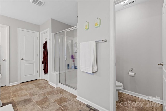 bathroom with a shower with shower door and toilet