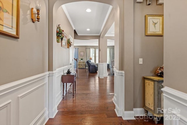 hallway with dark wood-type flooring and ornamental molding