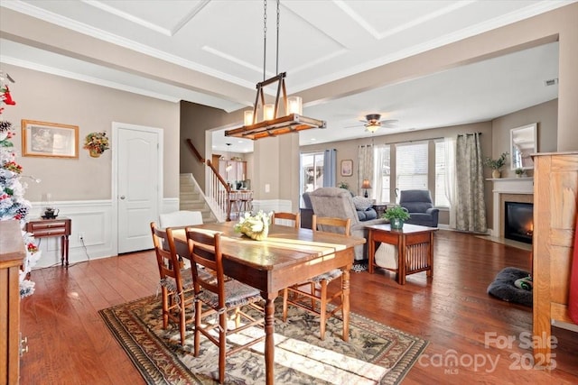 dining area with wood-type flooring, ornamental molding, and ceiling fan