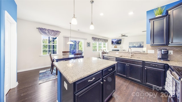 kitchen with tasteful backsplash, sink, a center island, stainless steel electric range oven, and hanging light fixtures