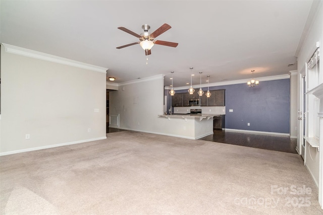 unfurnished living room with dark colored carpet, ceiling fan with notable chandelier, and crown molding