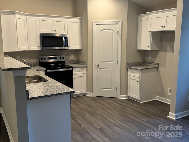 kitchen featuring white cabinets, stone countertops, dark hardwood / wood-style flooring, and appliances with stainless steel finishes