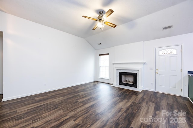 unfurnished living room featuring vaulted ceiling, ceiling fan, dark hardwood / wood-style floors, and a fireplace