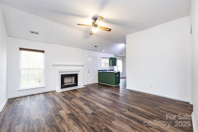 unfurnished living room with ceiling fan, dark hardwood / wood-style floors, a high end fireplace, and lofted ceiling