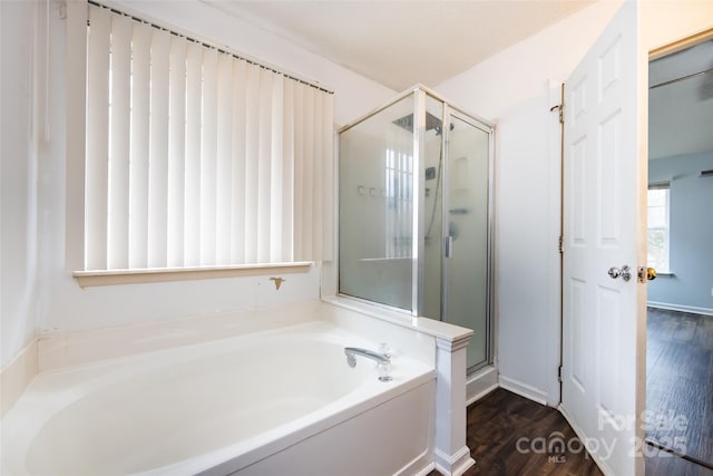 bathroom with hardwood / wood-style floors and shower with separate bathtub