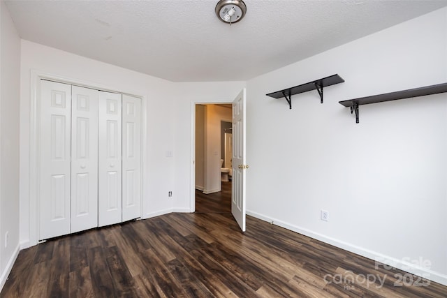 unfurnished bedroom featuring a closet, dark wood-type flooring, and a textured ceiling