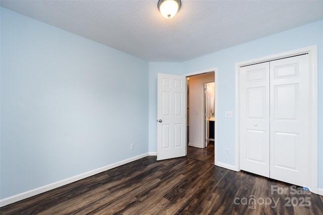 unfurnished bedroom featuring a textured ceiling, dark hardwood / wood-style floors, and a closet