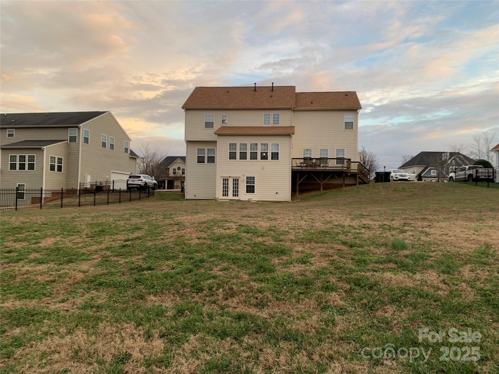 back house at dusk featuring a yard