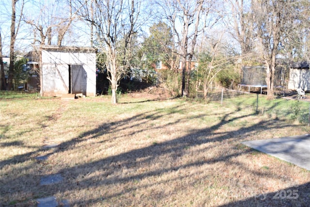 view of yard with a trampoline and a storage shed