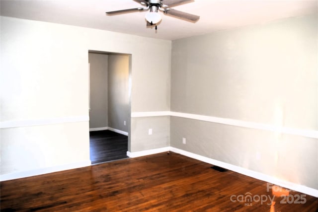 spare room with dark hardwood / wood-style flooring and ceiling fan