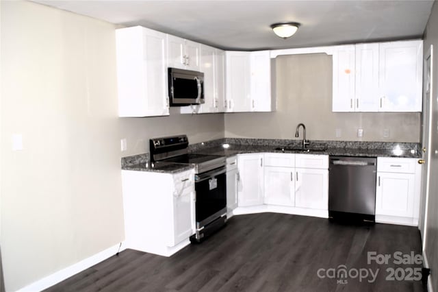 kitchen featuring dark hardwood / wood-style flooring, dark stone counters, stainless steel appliances, sink, and white cabinetry