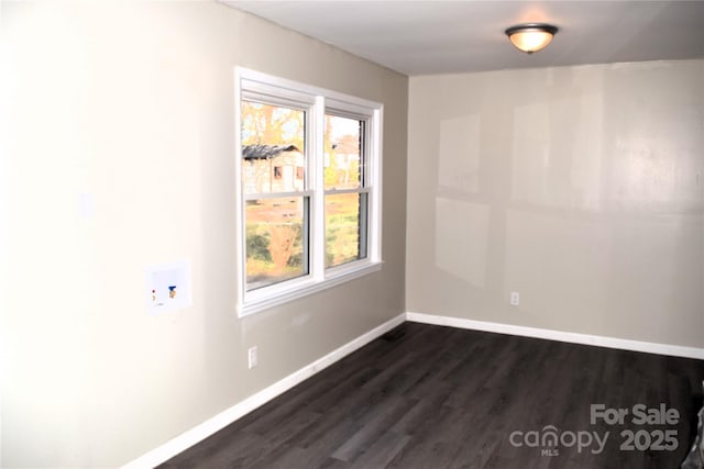 spare room with plenty of natural light and dark hardwood / wood-style flooring