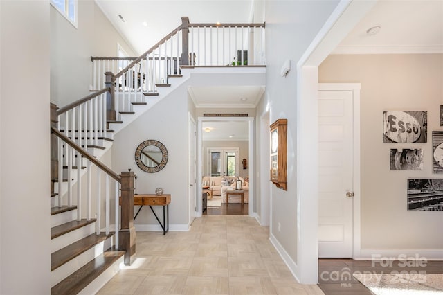 entrance foyer featuring a high ceiling, light parquet flooring, and ornamental molding