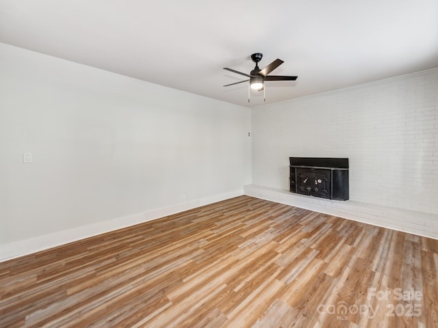 unfurnished living room with a fireplace, ceiling fan, and hardwood / wood-style flooring