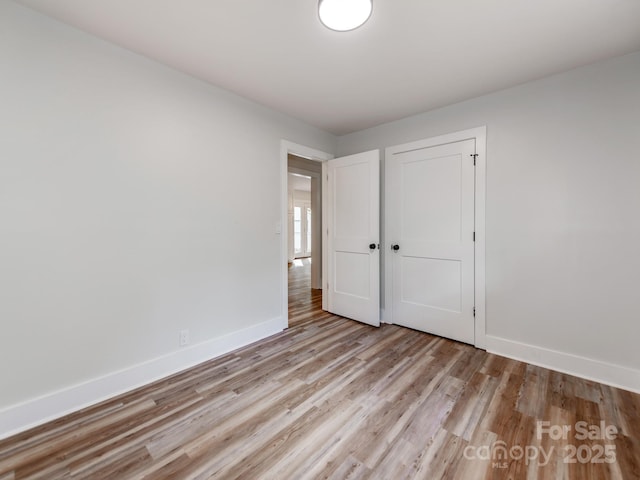 unfurnished bedroom with a closet and light hardwood / wood-style flooring