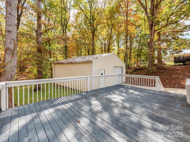 wooden terrace with an outbuilding, a garage, and a yard