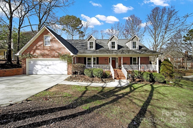 cape cod house with a porch, a garage, and a front yard