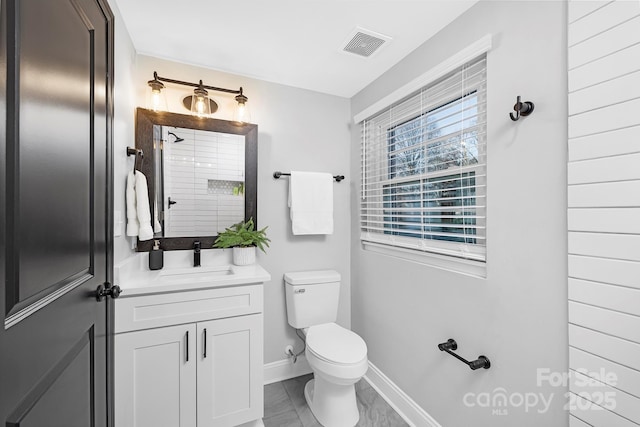 bathroom with tile patterned floors, vanity, toilet, and a healthy amount of sunlight