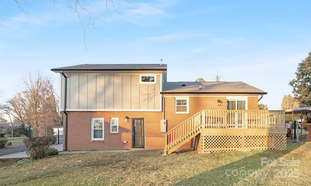 back of property featuring a wooden deck and a yard