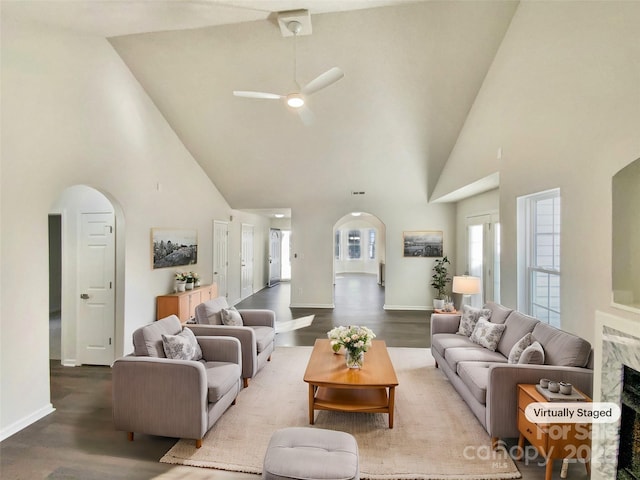 living room featuring ceiling fan, a towering ceiling, and hardwood / wood-style flooring