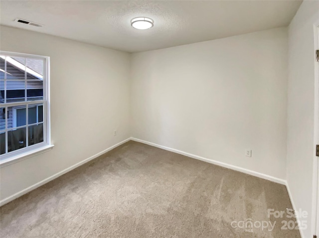 spare room with carpet and a textured ceiling