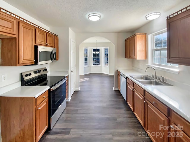 kitchen featuring dark hardwood / wood-style flooring, a textured ceiling, stainless steel appliances, and sink