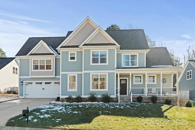 craftsman inspired home with a front yard, a garage, and a porch