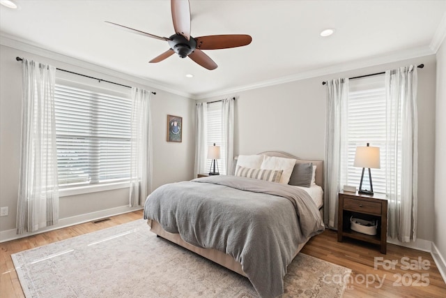 bedroom with ceiling fan, ornamental molding, hardwood / wood-style flooring, and multiple windows