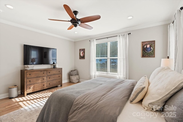 bedroom featuring ceiling fan, ornamental molding, and light hardwood / wood-style flooring