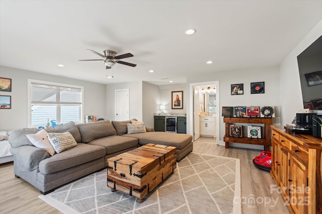 living room featuring light wood-type flooring, ceiling fan, and beverage cooler