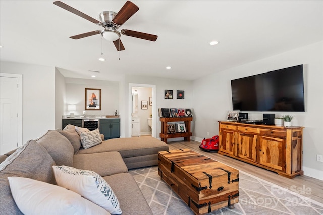 living room featuring ceiling fan, beverage cooler, and light hardwood / wood-style flooring