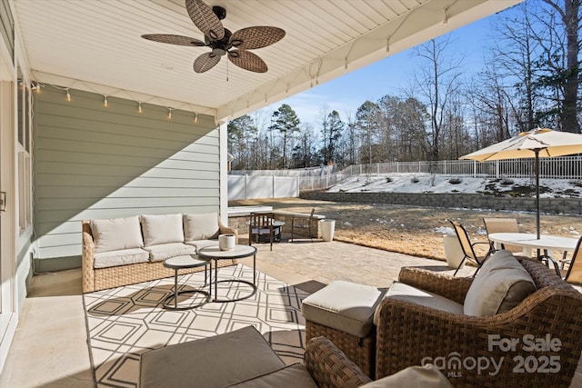 snow covered patio featuring ceiling fan and an outdoor hangout area