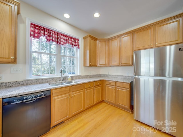 kitchen with light stone counters, sink, light hardwood / wood-style flooring, dishwasher, and stainless steel refrigerator