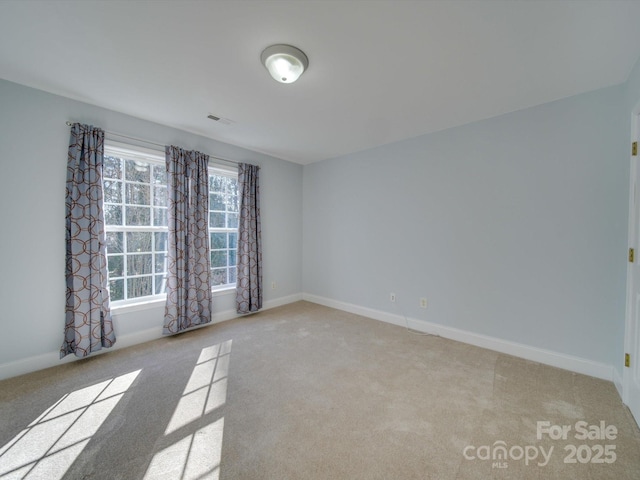 unfurnished room featuring light colored carpet