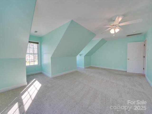 additional living space featuring ceiling fan, light colored carpet, and lofted ceiling