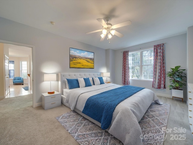 carpeted bedroom featuring multiple windows and ceiling fan