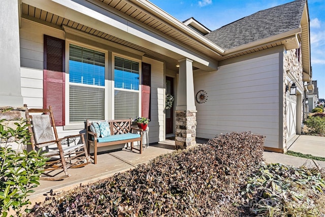 exterior space featuring a porch, an attached garage, and a shingled roof