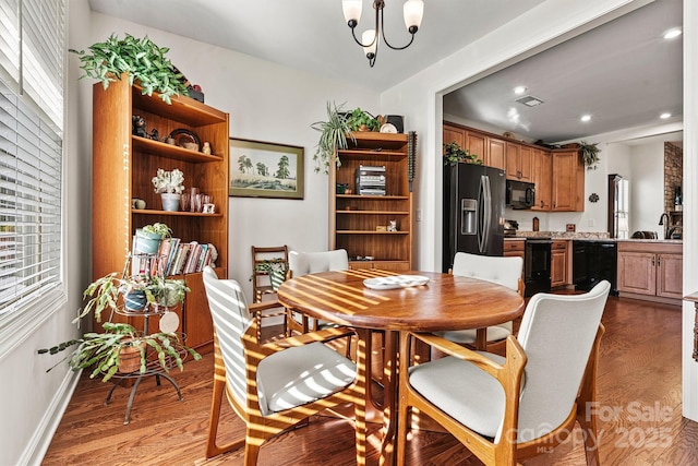 dining room featuring dark hardwood / wood-style flooring, an inviting chandelier, and plenty of natural light