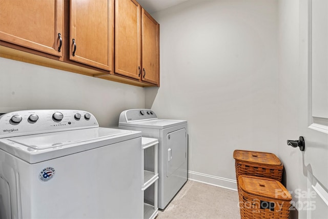 laundry room with light tile patterned flooring, cabinet space, independent washer and dryer, and baseboards