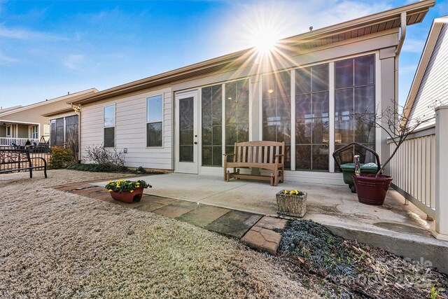 rear view of property featuring a sunroom and a patio area