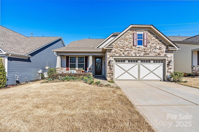 view of front of house featuring driveway, roof with shingles, an attached garage, a front lawn, and stone siding