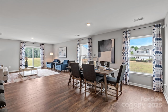 dining room with plenty of natural light and dark wood-type flooring