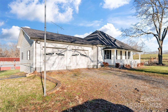 ranch-style house featuring covered porch, a garage, and a front yard