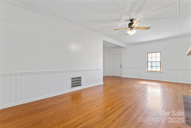 unfurnished room with ceiling fan, crown molding, and light hardwood / wood-style floors