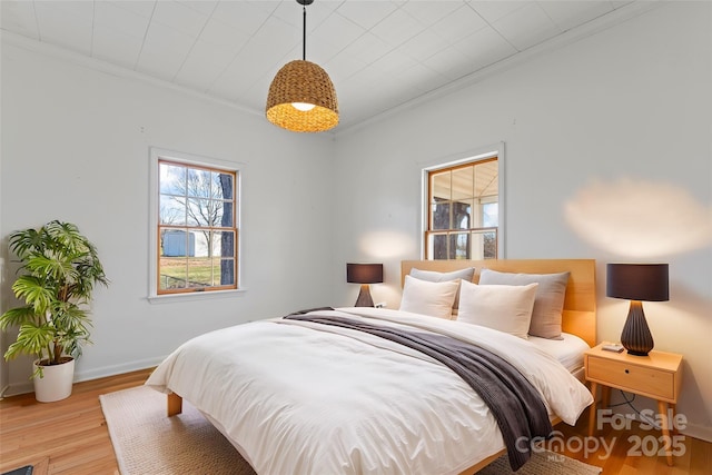 bedroom with light hardwood / wood-style flooring and ornamental molding